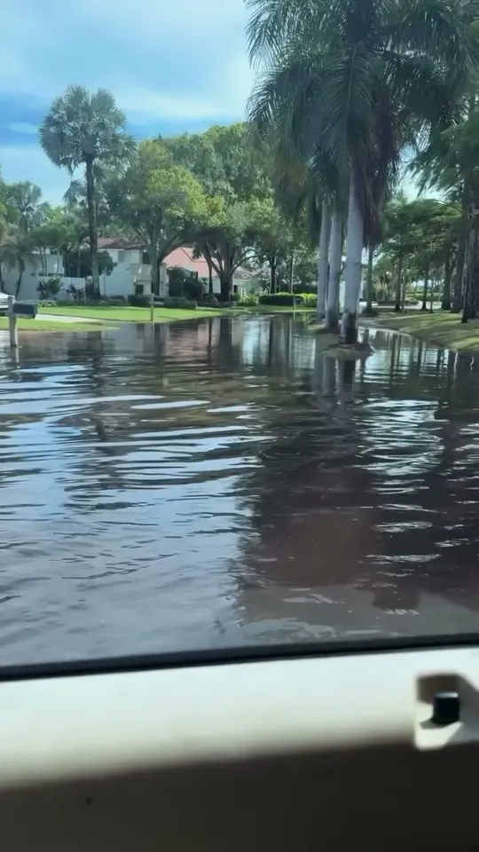Flooded residential street seen from a work truck